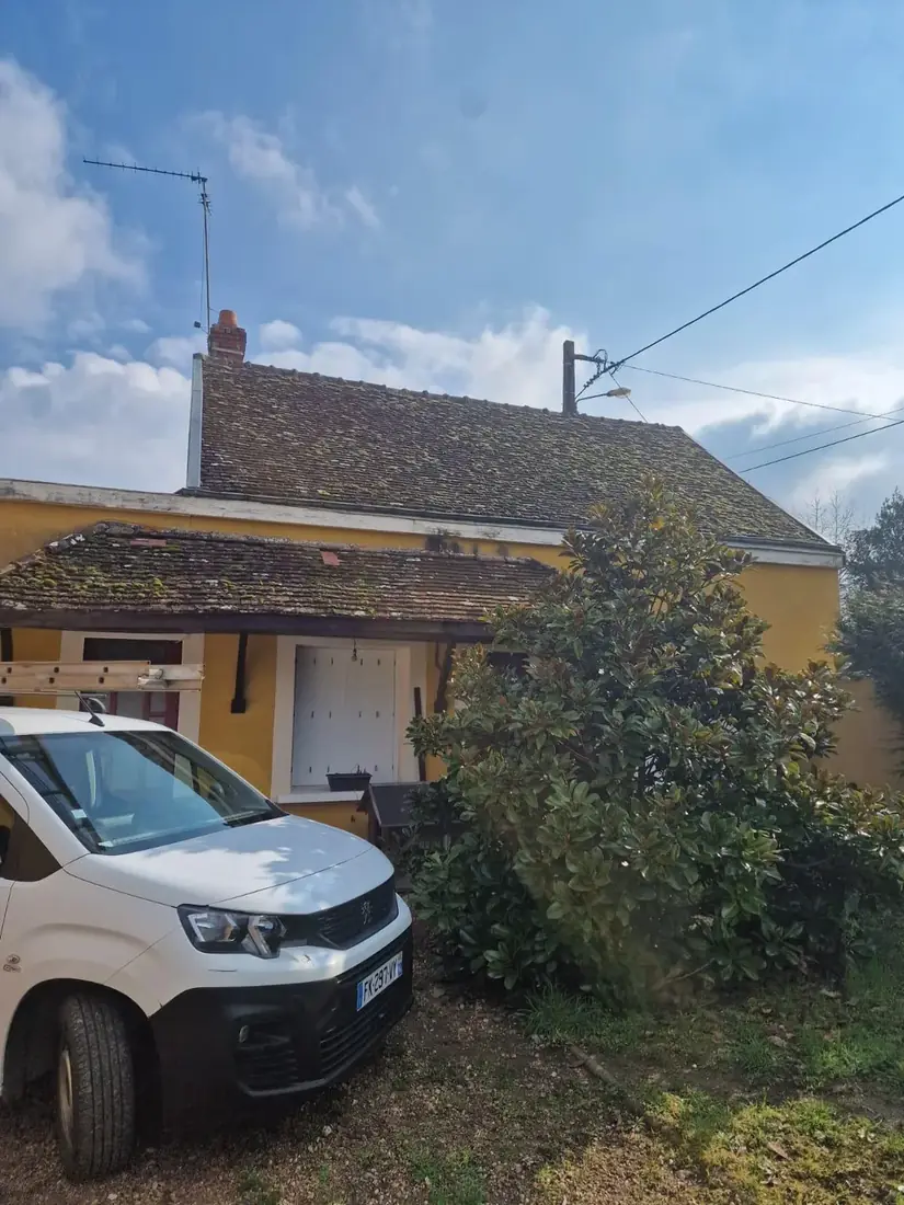 Fourgon de chantier garé devant une toiture à rénover, dans l'Indre